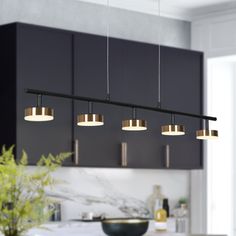 an image of a kitchen setting with lights hanging from the ceiling and cabinets in the background