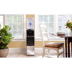 a water dispenser sitting in front of a window next to a dining room table