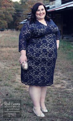 a woman in a blue dress is standing outside