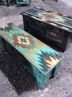 two wooden tables sitting next to each other on gravel