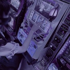 a woman using a vending machine in a convenience store with purple lights on it