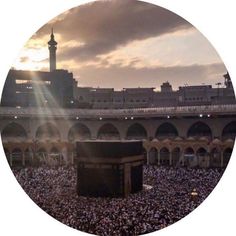 the sun is shining over an open area with many people in it and a large building