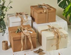 three wrapped gift boxes on a table with twine and ribbon tied around the edges