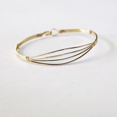 Here's an elegant and versatile square wire bracelet, a must-have addition to your jewelry collection. Crafted with four plain square 14kt gold filled wires, this spread-open design offers a head-turning and feminine look that is both timeless and chic. Its simplicity makes it perfect for stacking with other bangles, creating your own unique style statement. The built-in hook and eye-type clasp ensures easy wearability, allowing you to quickly put it on and take it off. This bracelet is designed Adjustable Bangle With Bracelet Strap For Everyday, Adjustable Everyday Bangle With Bracelet Strap, Adjustable Everyday Bangle, Adjustable Minimalist Bangle Bracelet, Everyday Adjustable Metal Cuff Bracelet, Modern Jewelry With Adjustable Band, Adjustable Stackable Bangle For Everyday, Adjustable Metal Bangle In Minimalist Style, Minimalist Adjustable Bangle Bracelet