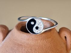 This tiny delicate ring is a beautifully crafted sterling silver piece, one centimeter in diameter, showcasing a unique interpretation of the Yin Yang symbol.  The delightful black and white design decorated with over 9 tiny crystals makes an ideal gift or treat yourself. This distinctive pendant is a harmonious blend of natural beauty and artistic design, making it a standout accessory.  MATCHING NECKLACE HERE: https://www.etsy.com/uk/listing/1660404741/tiny-ying-yang-crystal-sterling-silver?cl Spiritual Silver Stackable Rings For Gift, Symbolic Sterling Silver Stackable Rings, Dainty Adjustable Stackable Rings, Hallmarked, Dainty Hallmarked Stackable Rings, Dainty Round Stackable Rings Hallmarked, Dainty Adjustable Hallmarked Stackable Rings, Symbolic Adjustable Rings As Gifts, Spiritual Sterling Silver Stackable Rings, Symbolic Engraved Stackable Rings As Gift