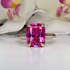 "The ring pictured is lab created sapphire #6419 Video shown in 14k white gold -Approximate total carat weight:  3.90ctw. diamond equivalent  -Center Stone Size:  10x8mm - approx. 3.90ct diamond equivalent  -Center Stone Shape: radiant cut  -Gem Type:  lab created pink sapphire -Stone Clarity: VS2 -Stone Color: pink -Moh's Scale: 9 hardness -Metal Type and Purity: 14k yellow gold -Setting: Claw Prong Brasket Head -Stock Ring Size: 6 -Country of Manufacturing:  USA (Michigan) For customization pl Luxury Pink Ruby Ring With Single Cut Diamonds, Luxury Pink Sapphire Ring For Promise, Luxury Pink Sapphire Ring For Anniversary, Luxury Pink Gold Sapphire Ring For Anniversary, Luxury Pink Sapphire Ring For Wedding, Luxury Pink Gold Rings With Pink Sapphire, Luxury Pink Sapphire Wedding And Engagement Rings, Pink Sapphire Set, Luxury Pink Square Cut Ring