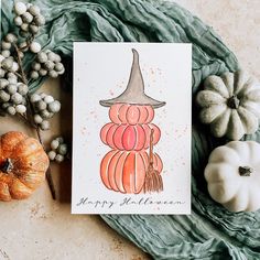 a happy halloween card with a witch hat and pumpkins on the table next to it