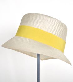 "\"Kami\" is pure elegance. The handmade hat is available in the high-quality \"parasisol\" with a lemmon yellow coloured hatband. Available in sizes 55 cm - 58 cm. Colour \"natur\" with a lemmon yellow coloured hatband and black accent Parasol hat (plaited straw) 66% cotton and 34% polyamide on the inside Ribbon of cotton and viscose Handmade Individualization options Other colours or sizes on request. All hats are handmade. For the production of a perfect hat it takes some time. All hats are r Chic Cream Toquilla Straw Boater Hat, White Elegant Straw Hat, Elegant White Straw Hat, Yellow Fedora With Short Brim, Yellow Fitted Fedora With Short Brim, Gold Curved Brim Straw Hat For Summer, Elegant Straw Brimmed Cloche Hat, Gold Wide Brim Straw Hat For Summer, Gold Straw Hat For Beach With Short Brim