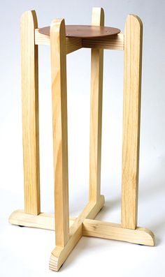 a small wooden table with two circular tables on it's legs and one standing upright