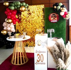 an assortment of balloons and decorations on display in a room with gold sequins