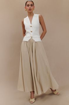 In flow.The CLARENCE is a an update on the iconic A-line linen maxi skirt. A true statement piece destined to be a core piece of your wardrobe, it features a high-waisted silhouette that cinches at the waist, complete with a waistband for added structure and definition. The A-line full skirt cascades gracefully to the floor, creating a sense of movement and fluidity with every step. Lined for comfort and opacity, we've crafted it with a concealed back zipper for a seamless finish. Linen Maxi Skirt, In Flow, Button Vest, Classy Casual Outfits, Classy Casual, Vest White, Brown Dress, Embellished Dress, Linen Dresses