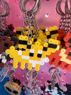 several different key chains are hanging on a pink wall and there is an image of a pacman in the middle