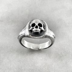 This skull ring is perfect for the macabre person in your life. This solid oxidised 925 sterling silver signet ring features a melted skull design. Solid oxidised 925 sterling silver signet ring featuring a melted skull design. Top of ring measures 1.3cm x 1.3cm 925 Oxidised Sterling Silver Each piece is handmade to order in the Jewel Thief Brighton atelier. Symbolic Engraved Skull Ring, Collectible Engraved Skull-shaped Rings, Gothic Skull Rings With Engraving, Gothic Skull Ring With Polished Finish Gift, Gothic Skull Ring With Polished Finish, Skull Ring With Polished Finish As Gift, Symbolic Oxidized Finish Skull Ring, Classic Skull Ring As Gift, Gift Skull Ring With Polished Finish