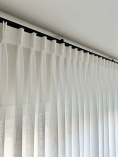 white curtains hanging on the side of a window