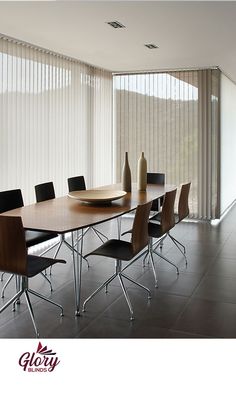 a dining room table with chairs and a vase on the table in front of it