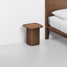 a bed with a wooden headboard and foot board next to a small end table