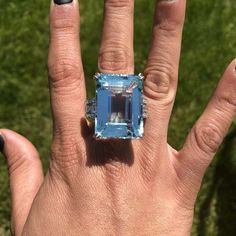 a woman's hand with a ring on it and an aqua colored stone in the middle