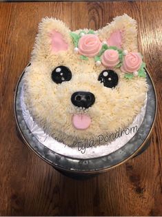 a cake that is shaped like a dog with flowers on it's head and ears