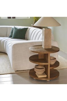 a white couch sitting next to a wooden table on top of a hard wood floor