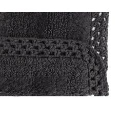 two black bath mats with crochet detailing on the edges and one has a white background