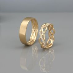 two gold wedding rings sitting on top of a table