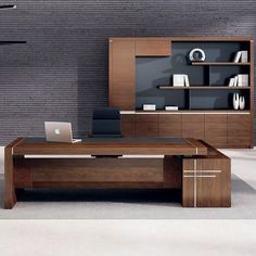 an office desk with a laptop on it in front of a book shelf and bookshelf