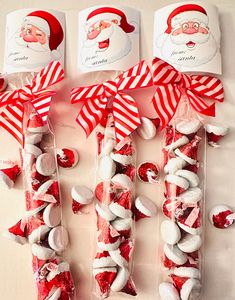 candy sticks with santa's face on them are wrapped in red and white paper