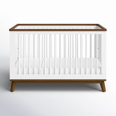 a white crib sitting on top of a wooden stand