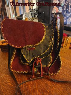 This small satchel is made using high quality wine colored Bison and black Deer leather. On the front is a nice sized pocket and above that is a Mahogany Obsidian needle from Davis Creek, California. Inside are two smaller pockets for extra storage. It comes with an adjustable cross body shoulder strap. All of the leather is treated with an all natural professional stain guard & water repellent. Approximately 9 inches (22.9 cm)by 8.5 inches (21.6 cm) by 3 inches (7.6 cm). Burgundy Leather Satchel For Fall, Fall Burgundy Leather Satchel, Red Leather Festival Bag, Leather Satchel With Adjustable Strap For Festivals, Red Leather Bohemian Satchel, Red Bohemian Leather Satchel, Bohemian Red Leather Satchel, Black Deer, Bison Leather