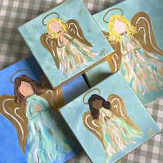 three paintings of angels on blue and green paper with gold foil accents, one is holding an angel's head