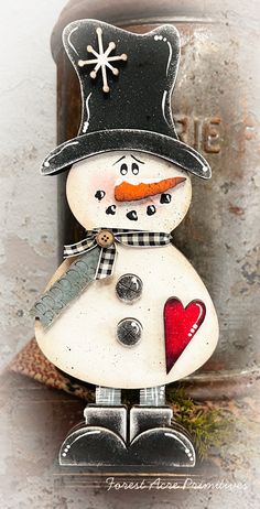 a close up of a snowman with a heart on it's nose and hat