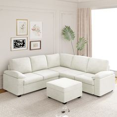 a living room with a large white sectional couch and footstool in front of a window