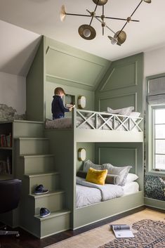 there is a boy that is sitting on top of the bunk bed in this room