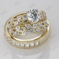 two gold wedding rings with diamonds on each one and an engagement ring in the middle