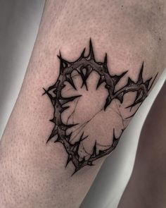 a black and white tattoo on the leg of a man's arm with a circular design