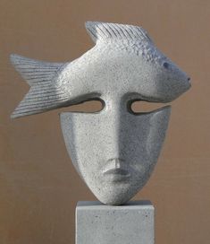 a white sculpture with a fish on it's head