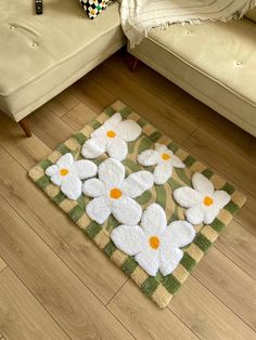 a rug with white flowers on it in front of a couch