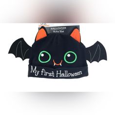 a black cat hat with green eyes and an orange bat on it's back