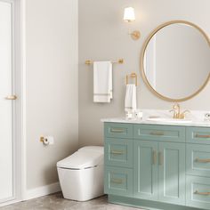 a white toilet sitting next to a blue vanity in a bathroom under a round mirror