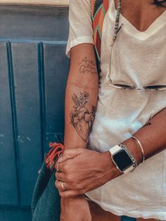 a woman with a tattoo on her arm holding a purse and looking at the camera