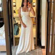 a woman in a white dress taking a selfie