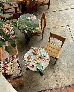 an overhead view of a table and chairs with food on it