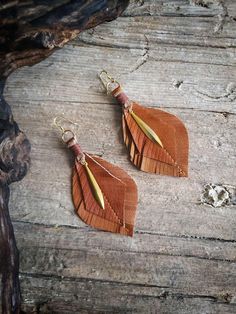 Add a natural boho touch to your outfit with these Southwestern-style leather feather earrings.  Made from genuine leather upcycled from a vintage jacket, these earrings feature two layers of soft leather, stitched down the center for added detail.  Paired with a delicate gold-colored charm and finished with gold-plated ear wires, they're lightweight, cute, and comfortable for all-day wear.  Perfect for anyone looking to add a unique, handmade accessory to their collection, these earrings bring a rustic yet elegant feel to any look. SIZE Length: 9 cm Width: 4 cm MATERIALS Genuine leather upcycled from vintage leather jacket COLOUR Front: Clay brown Back: Pale brown DETAILS Gold plated ear wire Gold colored charm Waxed string NOTE Any imperfection in materials is proof that it is recycled, Handmade Brown Bohemian Plug Earrings, Handmade Bohemian Brown Plug Earrings, Nickel-free Brown Bohemian Earrings, Brown Bohemian Dangle Earrings, Bohemian Brown Pierced Earrings, Handmade Brown Earrings For Festival, Brown Dangle Jewelry For Festivals, Brown Dangle Jewelry For Festival, Unique Brown Festival Earrings