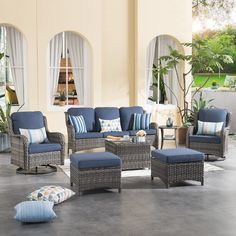 an outdoor living room with wicker furniture and blue cushions