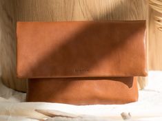 Tan brown leather clutch. Handmade designer clutch made of vegetable-tanned leather. The simple design of this bag lets the women feel unique and stylish and perfectly fits with all outfits.  We use carefully selected genuine vegetable tanned leather from Italian (Tuscany) manufacturers.  Below there are some more detailed features of the backpack: * The dimensions of the bag are 16.7 x 7.9 x 0.8 in (17 x 20 x 2 cm). * There is one section inside. * The color of the bag is brown. * Soft leather. Minimalist Leather Rectangular Clutch, Modern Leather Clutch For Everyday, Minimalist Rectangular Leather Clutch, Modern Everyday Leather Clutch, Versatile Leather Clutch With Smooth Grain, Minimalist Leather Clutch For Everyday Use, Minimalist Leather Clutch For Travel, Minimalist Everyday Rectangular Clutch, Everyday Minimalist Rectangular Clutch