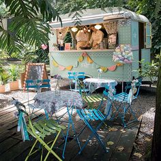 there are many chairs and tables in front of the food truck