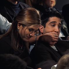 two people sitting next to each other at a fashion show