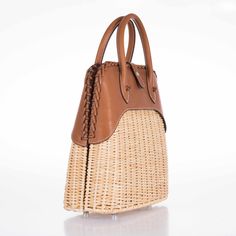 This Hermes Picnic Bolide, crafted in 2017, is an exquisite blend of rustic charm and refined elegance. This unique bag marries the natural beauty of Osier Wicker with the luxurious touch of Fauve Barenia leather, creating an accessory that is both visually stunning and tactilely inviting. The body of the bag is made from finely woven Osier Wicker, evoking the essence of serene summer days and elegant countryside escapades. This natural material adds an element of artisanal craftsmanship and giv Elegant Leather Straw Bag With Detachable Handle, Elegant Brown Handwoven Straw Bag, Elegant Handwoven Brown Straw Bag, Elegant Rectangular Leather Straw Bag, Elegant Leather Woven Straw Bag, Elegant Brown Straw Bag With Woven Leather, Elegant Leather Straw Bag With Leather Handles, Elegant Natural Basket Bag, Elegant Natural Color Basket Bag