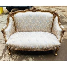 an ornately decorated couch sitting on the ground