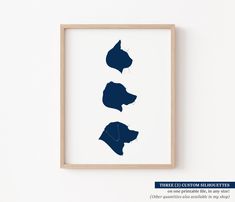 three silhouettes of dogs on a white background in a wooden frame hanging on the wall